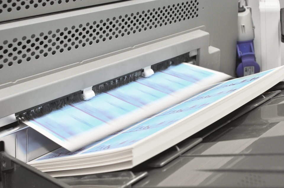 Une imprimante professionnelle grand format en fonctionnement produisant des impressions couleur sur papier